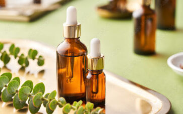 Essential oils and green plant on tray